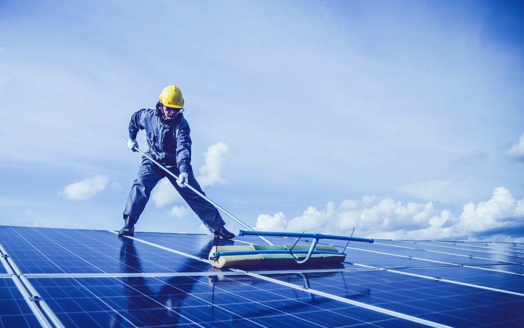 Man Cleaning Solar Panels on Roof Photo